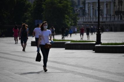 Москва. Девушка в медицинской маске на улице после отмены режима самоизоляции, введенного из-за пандемии коронавируса.