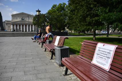 Москва. Объявление о соблюдении  социальной дистанции на скамейках в сквере Большого театра  после отмены режима самоизоляции, введенного  из-за пандемии коронавируса.