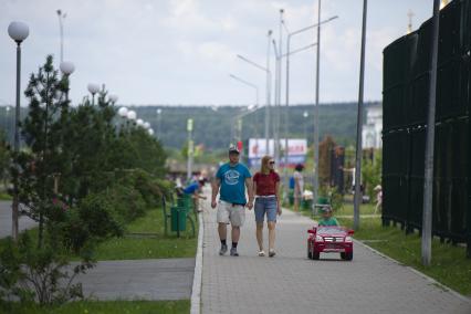 Екатеринбург. Семья с ребенком гуляют с на аллее