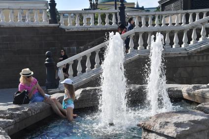 Москва.  Женщина с девочкой у фонтана  Времена года на Манежной площади после отмены режима самоизоляции, введенного  из-за пандемии коронавируса.