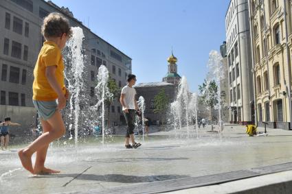 Москва.   Дети играют у фонтана  на Биржевой площади после отмены режима самоизоляции, введенного  из-за пандемии коронавируса.