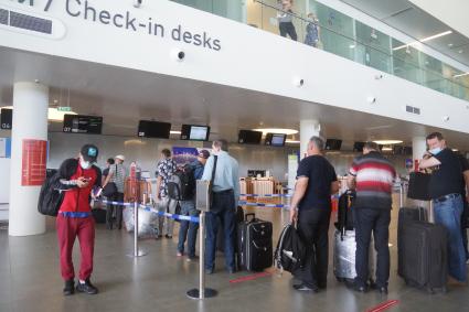 Самара. Пассажиры в очереди на регистрацию на рейс в международном аэропорту Самара (Курумоч) имени С.П. Королева во время пандемии коронавируса COVID-19.