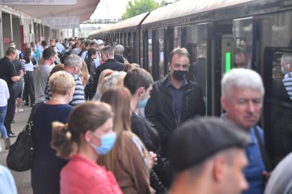 Москва.  Пассажиры метрополитена  в медицинских масках на платформе.