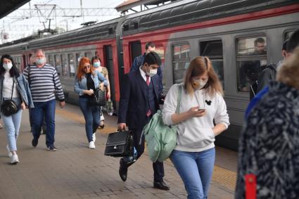 Москва.  Пассажиры пригородных поездов   в медицинских масках на платформе.