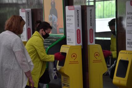 Москва.  Пассажиры метрополитена  в медицинских масках обрабатывают руки антисептиком.