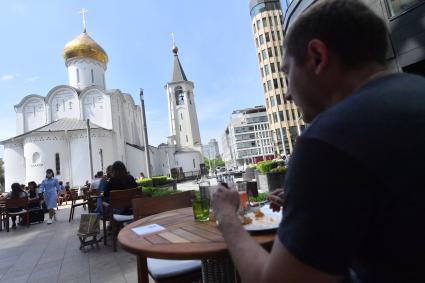 Москва. Посетители на летней веранде кафе `Кофемания`.