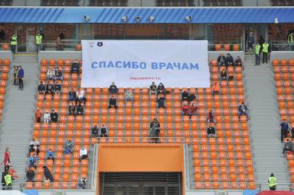 Екатеринбург. Болельщики на трибунах футбольного стадиона \'Екатеринбург-арена\' с широкой рассадкой болельщков для соблюдения 1.5 метровой социальной дистанции, перед началом матча премьер-лиги \'Урал\' 1-2 \'Рубин\'. Из-за эпидемии новой коронавирусной инфекции проведение футбольных матчей было запрещено, после ослабления противоэпидемического режима, было разрешено проводить массовые мероприятия при условии соблюдения противоэпидемических мер