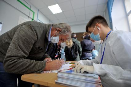 Екатеринбург. Первый день предварительного голосования по поправкам в Конституцию РФ 1 июля 2020г. Из-за эпидемии новой коронавирусной инфекции COVID-19 на избирательных участках организованы противоэпидемические мероприятия (измерение температуры тела, обработка рук антисептиком, выдача одноразовых перчаток)