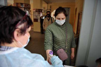 Екатеринбург. Первый день предварительного голосования по поправкам в Конституцию РФ 1 июля 2020г. Из-за эпидемии новой коронавирусной инфекции COVID-19 на избирательных участках организованы противоэпидемические мероприятия (измерение температуры тела, обработка рук антисептиком, выдача одноразовых перчаток)