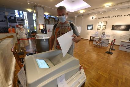 Москва. Мужчина во время голосования по вопросу внесения поправок в Конституцию РФ на избирательном участке.