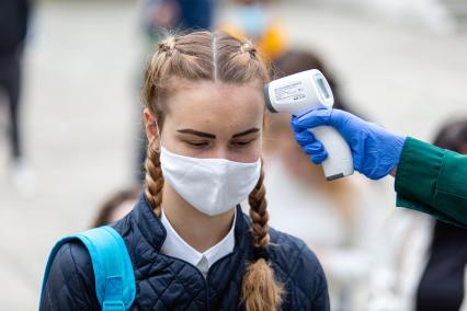 Челябинск. Измерение температуры тела школьнице перед началом единого государственного экзамена (ЕГЭ).