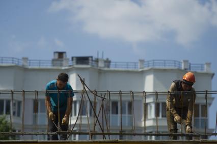 Екатеринбург. Новый жилой район \'Академический\'. Рабочие вяжут арматуру на стройке жилого дома