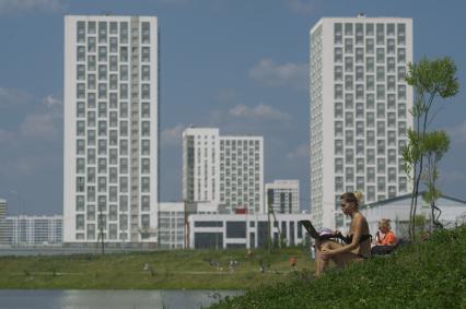 Екатеринбург. Новый жилой район \'Академический\'. Девушка в купальнике с ноутбуком загарает в преображенском парке