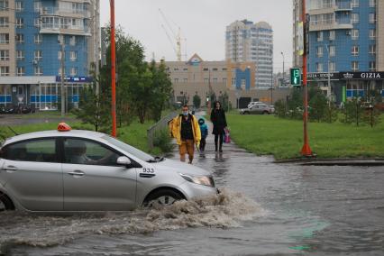 Красноярск. Машины едут по лужам во время дождя.