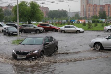 Красноярск. Машины едут по лужам во время дождя.