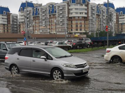 Красноярск. Машины едут по лужам во время дождя.