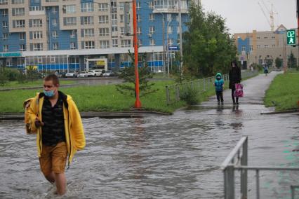 Красноярск. Пешеходы переходят  затопленную улицу.