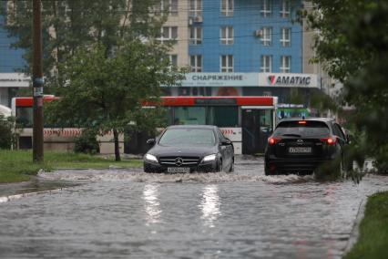 Красноярск. Машины едут по лужам во время дождя.