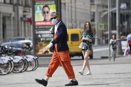 Москва. Мужчина в медицинской маске на улице города.