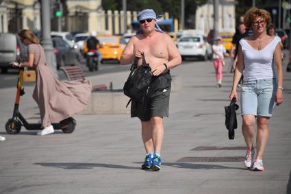 Москва. Мужчина с голым торсом на улице города.