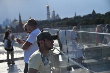 Москва. Отдыхающие  на  Парящем мосту парка Зарядье.