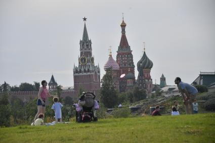 Москва. Женщина с детьми отдыхает на газоне парка Зарядье.