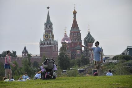 Москва. Женщина с детьми отдыхает на газоне парка Зарядье.