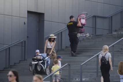 Екатеринбург. Охранник помогает женщине поднять детскую коляску по лестнице