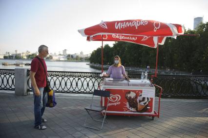 Екатеринбург. Девушка-продавщица мороженого на набережной реки Исеть во время летней жары
