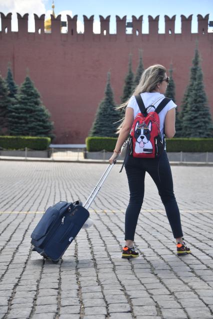 Москва. Девушка с чемоданом на Красной площади.