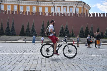 Москва. Мужчина на велосипеде на Красной площади.