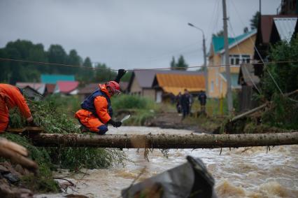 Свердловская область. Нижние Серги. Ликвидация последствий разлива реки Заставка из-за сильного ливня. Река размыла одну из улиц и потоком были смыты несколько домов, гаражей и автомобилей. Спасатели прокладывают временный мост