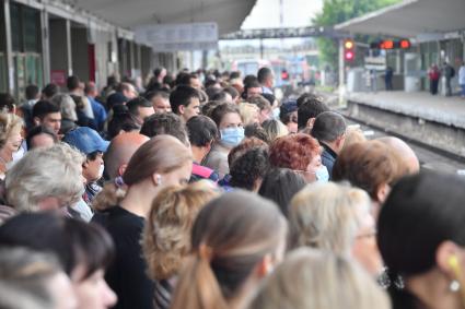 Москва. Пассажиры в ожидании поезда на платформе станции метро `Выхино`.