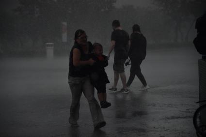 Москва.   Женщина с ребенком под дождем.