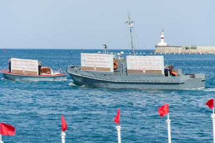 Севастополь. Катер с плакатом погибшего корабля в годы ВОВ во время военно-морского парада в честь Дня ВМФ России.