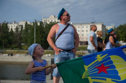 Екатеринбург. Мужчина служивший в ВДВ с сыном наблюдает за посадкой группы парашютистов ДОСААФ во время празднования дня ВДВ