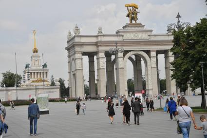 Москва.   Посетители у арки Главного входа ВДНХ.