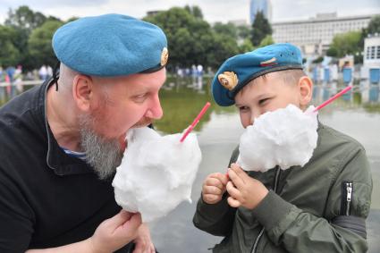 Москва. Мужчина с ребенком едят сладкую вату во время празднования Дня Воздушно-десантных войск в Парке Горького.