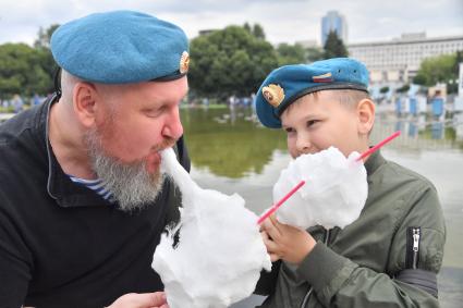 Москва. Мужчина с ребенком едят сладкую вату  во время празднования Дня Воздушно-десантных войск в Парке Горького.