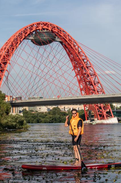 Москва. Молодой человек занимается SUP-серфингом.