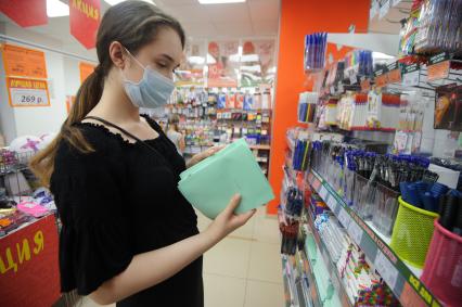 Екатеринбург. Женщина в магазине выбирает канцтовары для детей перед началом нового учебного года