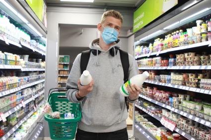Иркутск. Молодой человек в медицинской маске в продуктовом магазине.
