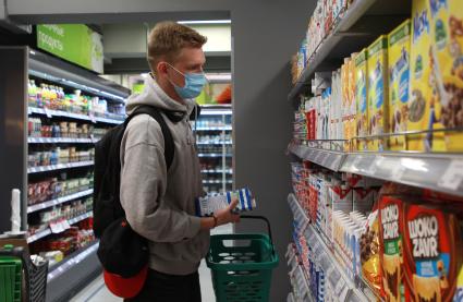 Иркутск. Молодой человек в медицинской маске в продуктовом магазине.