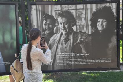 Москва.  Прохожие на открытии фотовыставки, посвященной 85-летию  Олега Табакова на Чистопрудном бульваре.