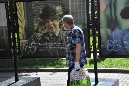 Москва.  Прохожие на открытии фотовыставки, посвященной 85-летию  Олега Табакова на Чистопрудном бульваре.