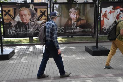 Москва.  Прохожие на открытии фотовыставки, посвященной 85-летию  Олега Табакова на Чистопрудном бульваре.