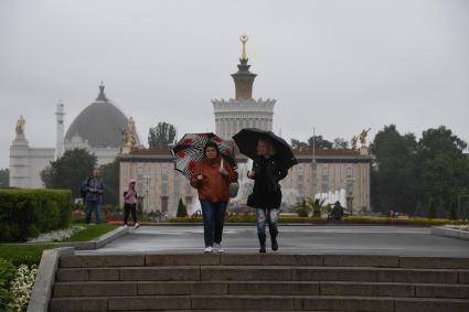 Москва. Женщины под зонтом гуляую на ВДНХ.