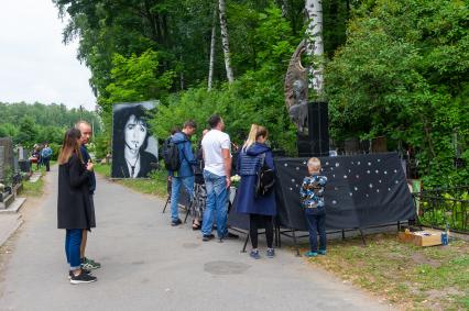 Санкт-Петербург. Поклонники музыканта Виктора Цоя  у его могилы на Богословском кладбище, в день 30-й годовщины со дня его смерти.