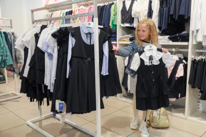 Красноярск. Девочка выбирает школьную форму в магазине.