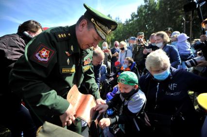 Екатеринбург. Танковый полигон 32-го военного городка. Международный военно-технический форум \'Армия-2020\'. Командующий восками ЦВО генерал-лейтенант Александр Лапин вручает подарки детям-инвалидам после церемонии открытия форума